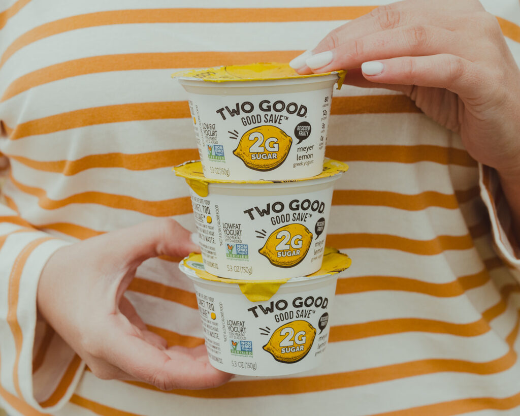 Two Good Yogurt -picture holding Two Good Good Save Lemon flavored Greek Yogurt