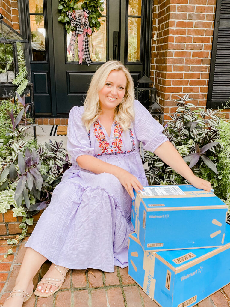 Walmart+ Membership - woman sitting in purple dress with Walmart+ boxes