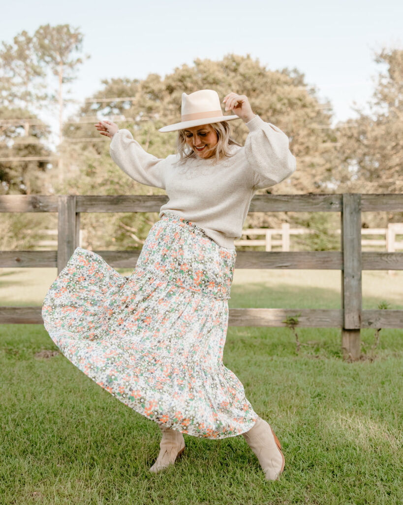 5 Trends to Try This Fall | Sell Eat Love. Woman outside wearing long floral skirt, sweater, western hat and Western Boots. 